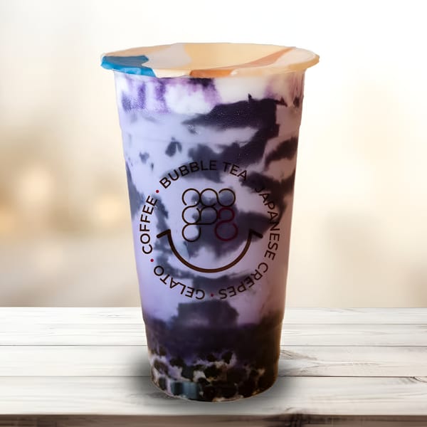 Eight Turn Crepe's purple bubble tea with dark swirls and tapioca pearls on a white wooden table.