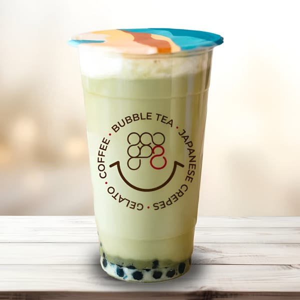 Eight Turn Crepe's green bubble tea with tapioca pearls, topped with foam and a colorful lid.