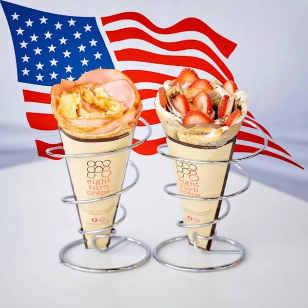 Two Eight Turn Crepes, one savory and one sweet, in front of an American flag.