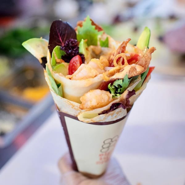 A savory Eight Turn Crepe filled with shrimp, avocado, lettuce, tomatoes, and crispy fried onions.