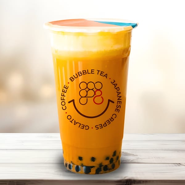 Eight Turn Crepe's bubble tea, a yellow drink with tapioca pearls, topped with foam.