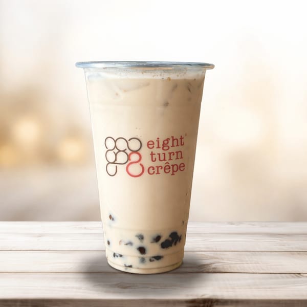 Eight Turn Crepe's bubble tea with tapioca pearls, on a light wooden table.